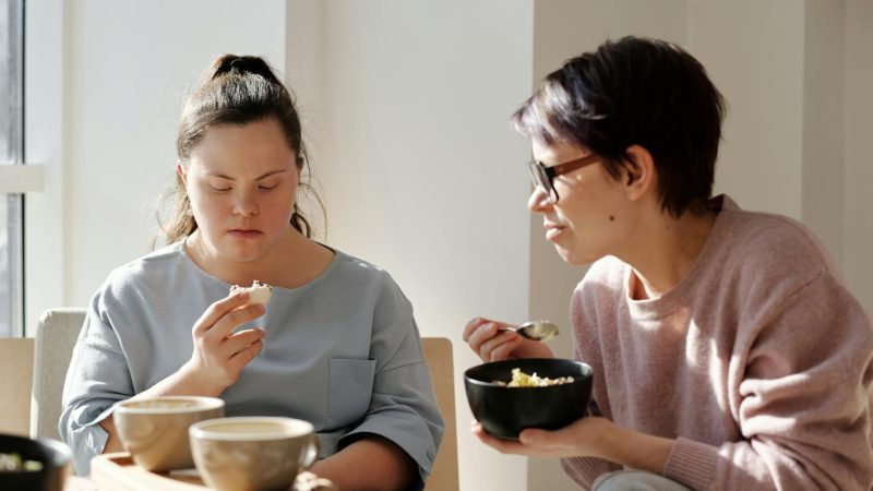 women eating near a white wall