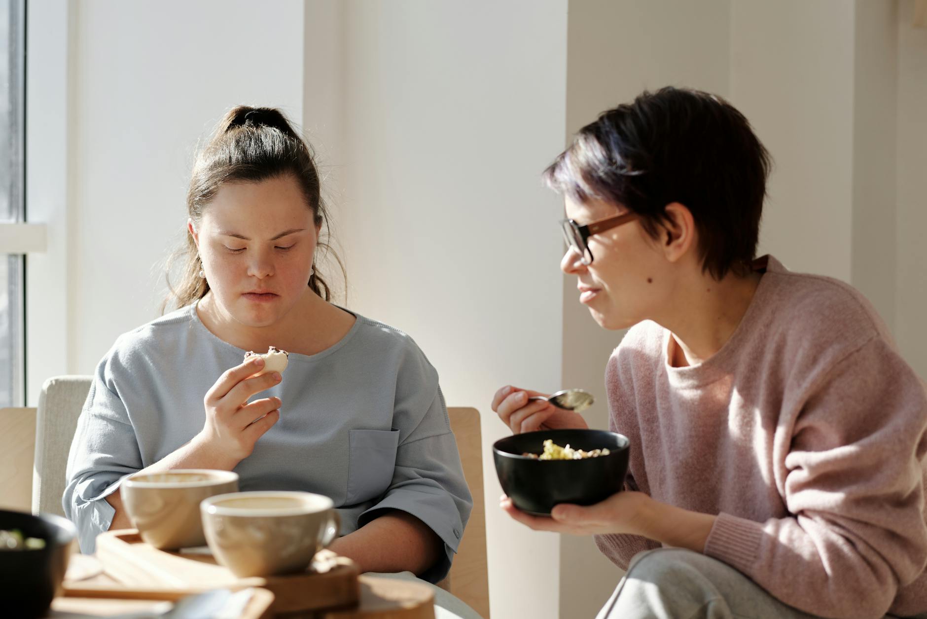 women eating near a white wall
